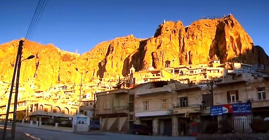 Homes tumble down the cliff face to the main access road to Maaloula.